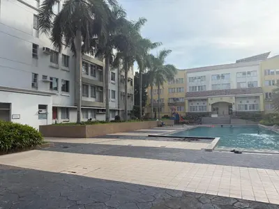 a swimming pool in a courtyard with palm trees and buildings at Manggahan General Trias Cavite in General Trias
