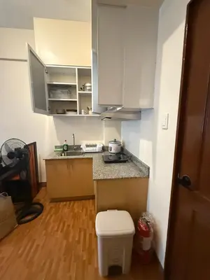 a small kitchen with white cabinets and a toilet at Manggahan General Trias Cavite in General Trias