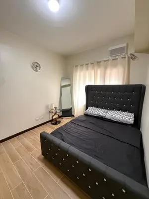 a bedroom with a large black bed in a room at Paseo Verde at Real in Manila