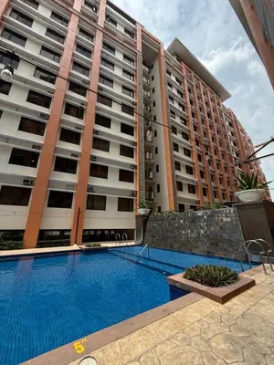 a swimming pool in front of a large apartment building at Paseo Verde at Real in Manila