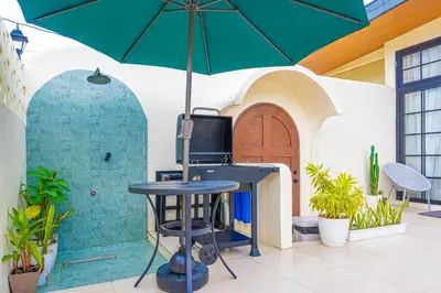a patio with a table and an umbrella at Casa Dapyo in Sampong