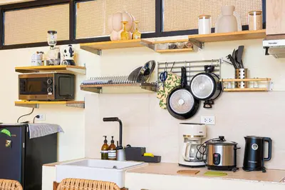 a kitchen with a counter with pots and pans on the wall at Casa Dapyo in Sampong
