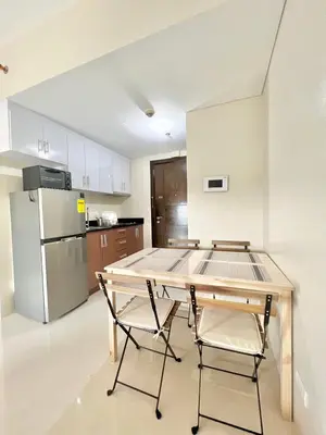 a kitchen with a table and two chairs and a refrigerator at KIEL HOTEL - Manila Airport NAIA Terminal 3 in Manila