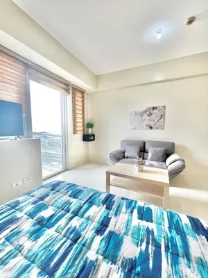 a bedroom with a bed and a couch and a window at KIEL HOTEL - Manila Airport NAIA Terminal 3 in Manila