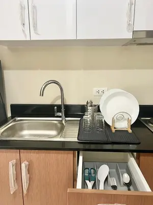 a kitchen counter with a sink and a plate and utensils at KIEL HOTEL - Manila Airport NAIA Terminal 3 in Manila