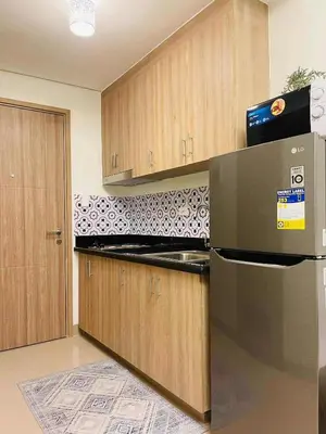 a kitchen with a stainless steel refrigerator and wooden cabinets at Jaiden & Blake Sweet Home in Manila