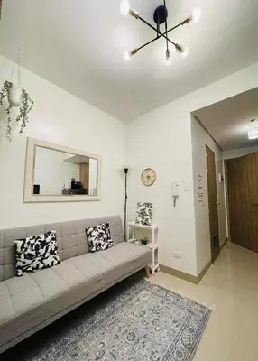 a living room with a couch and a mirror at Jaiden & Blake Sweet Home in Manila