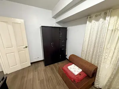 a living room with a couch and a cabinet at 1BR LaVerti Minalist affordable family staycation in Manila