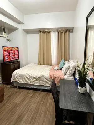 a small bedroom with a bed and a table at 1BR LaVerti Minalist affordable family staycation in Manila