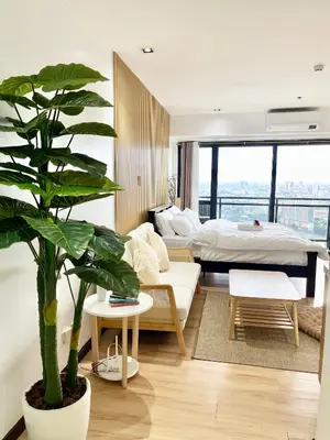 a bedroom with a bed and a potted plant at Modern Studio with Balcony at Knightsbridge Residences, Poblacion Makati in Manila