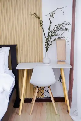 a white table with a vase and a white chair at Modern Studio with Balcony at Knightsbridge Residences, Poblacion Makati in Manila