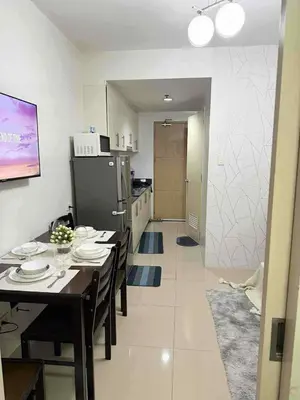 a dining room with a table and a kitchen at 1Br Sea Residences affordable staycatiom in Manila