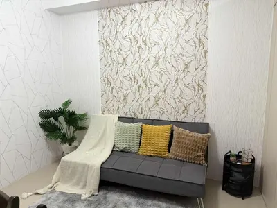 a living room with a couch with pillows on it at 1Br Sea Residences affordable staycatiom in Manila