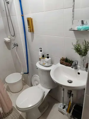 a white bathroom with a toilet and a sink at Cambridge cozy 2BR condo in San Andres