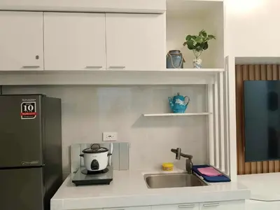 a kitchen counter with a sink and a coffee maker at Grace Residences Taguig in Manila