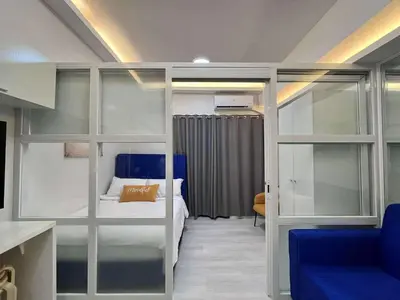 a bedroom with a bunk bed and a blue chair at Grace Residences Taguig in Manila