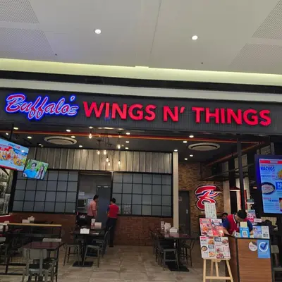 a restaurant with a sign that reads buhler wings n things at Jazz Tower A Cozy Room for 2 Adults in Manila