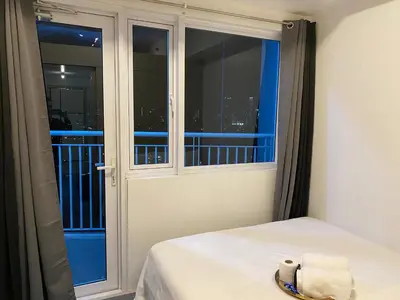 a bedroom with a window with a view of the city at Jazz Tower D Superb view with Queen Bed in Manila