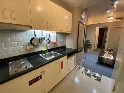 a kitchen with white cabinets and black counter tops at Jazz Tower D Superb view with Queen Bed in Manila