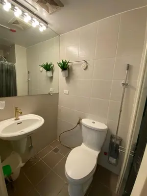 a white bathroom with a toilet and a sink at Jazz Tower D Superb view with Queen Bed in Manila