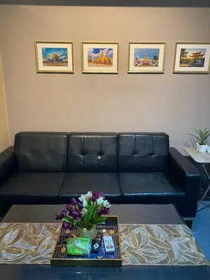 a black leather couch in a living room with flowers on a table at Jazz Tower D Superb view with Queen Bed in Manila