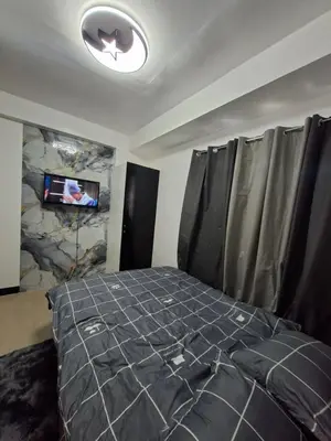 a bedroom with a bed and a tv on a wall at Pod 520 in Manila