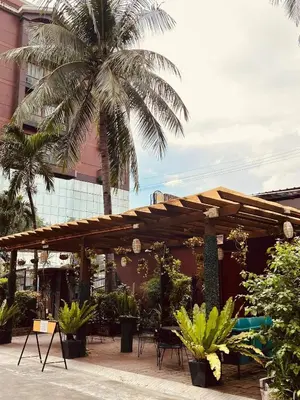 a wooden pergola with a palm tree in front of a building at Pod 520 in Manila