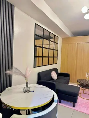 a living room with a table and a couch at MOA Staycation Condotel in Manila