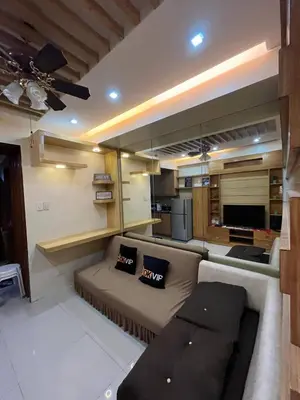 a living room with a couch and a kitchen at MOA Staycation Condotel in Manila