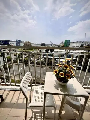 a table and chairs with a bowl of flowers on a balcony at MOA Staycation Condotel in Manila