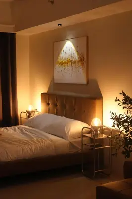 a bedroom with a bed with a painting on the wall at Bruné - Parañaque in Manila