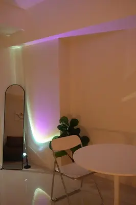 a table and chair in a room with a purple light at Bruné - Parañaque in Manila