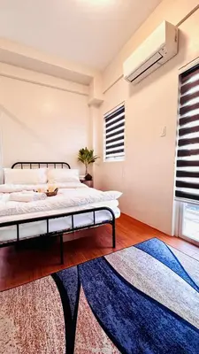 a bedroom with a large bed and a rug at Minimalist Condo near NAIA Free Netflix Pool Balcony in Manila