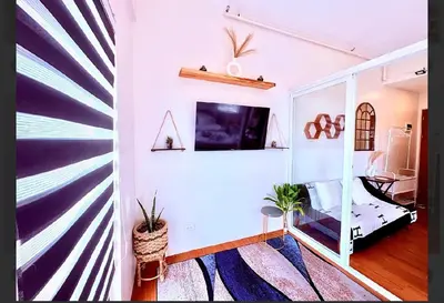 a living room with a wall with a mural at Minimalist Condo near NAIA Free Netflix Pool Balcony in Manila