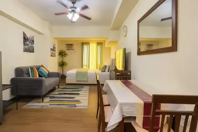 a living room with a bed and a couch at La Verti Residences 1524 in Manila