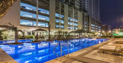 a swimming pool in front of a building at night at La Verti Residences 1524 in Manila