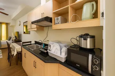 a kitchen with a sink and a microwave at La Verti Residences 1524 in Manila