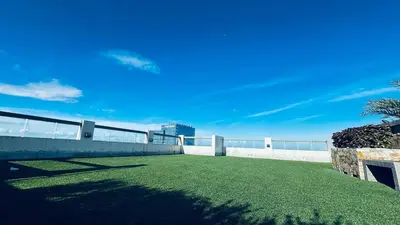 a yard with green grass and a white fence at La Verti Residences 1520 in Manila