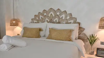 a bedroom with a large white bed with two pillows at Nusa Villa in Malinta