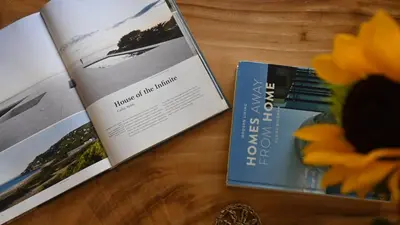 two books sitting on a table with flowers at Nusa Villa in Malinta