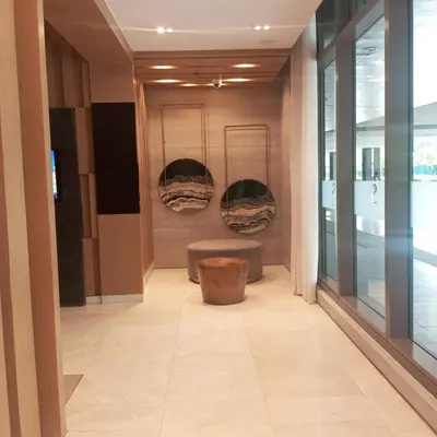 a hallway of a building with a bench in a room at Modern MOA Escape, Work, Chill & City Views in Manila