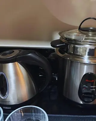 a slow cooker with a pot on a stove at Modern MOA Escape, Work, Chill & City Views in Manila