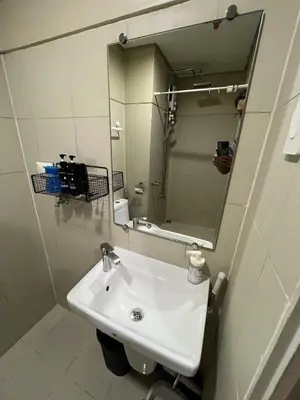 a bathroom with a white sink and a mirror at Modern MOA Escape, Work, Chill & City Views in Manila