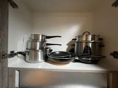 a shelf with pots and pans on top of a stove at Comfort & Productivity Rainy Season WFH Retreat in Manila