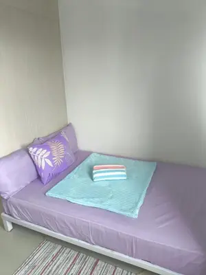 a purple couch in a room with a pillow at Sea Residence-Rosa in Manila
