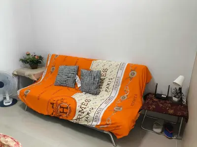 an orange couch with two pillows on it in a room at Sea Residence-Rosa in Manila
