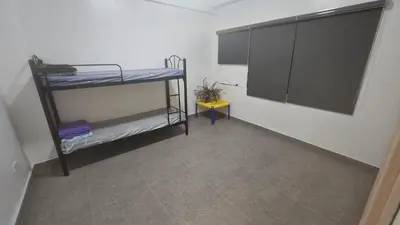 a room with two bunk beds and a table at Nemar Building 204 in Manila
