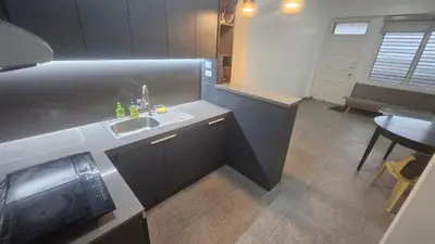 a small kitchen with a sink and a table at Nemar Building 204 in Manila