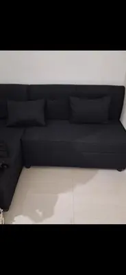 a black couch with pillows on top of a room at SMDC South Residences in Manila