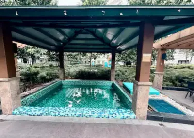 a swimming pool under a pavilion with a blue roof at Walkable to and from NAIA 3 and Resorts World in Manila